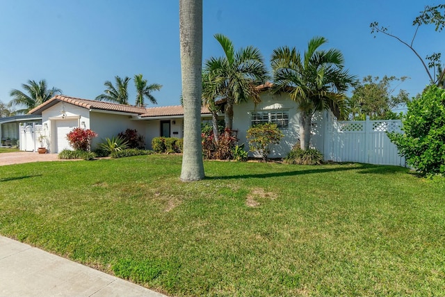 view of front of house featuring an attached garage, fence, decorative driveway, stucco siding, and a front lawn