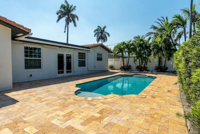 view of pool with a fenced in pool, french doors, a fenced backyard, and a patio