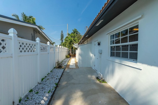 view of side of property with a patio area, a fenced backyard, and stucco siding