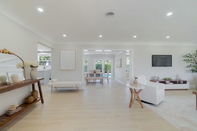 living room featuring light wood finished floors, plenty of natural light, visible vents, and recessed lighting