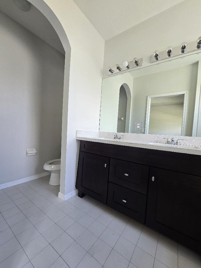 full bath featuring double vanity, tile patterned flooring, toilet, and baseboards