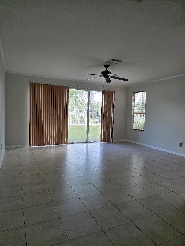 unfurnished room with ceiling fan, baseboards, visible vents, and crown molding