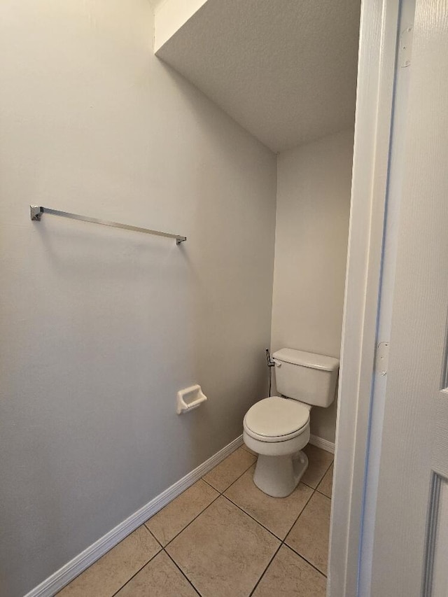 bathroom featuring tile patterned flooring, toilet, and baseboards