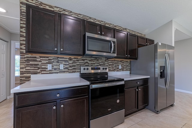 kitchen featuring light tile patterned floors, light countertops, appliances with stainless steel finishes, and decorative backsplash