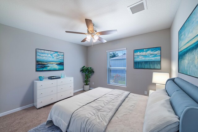 carpeted spare room featuring a ceiling fan, visible vents, a textured ceiling, and baseboards