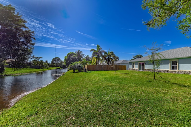 view of yard featuring a water view and fence