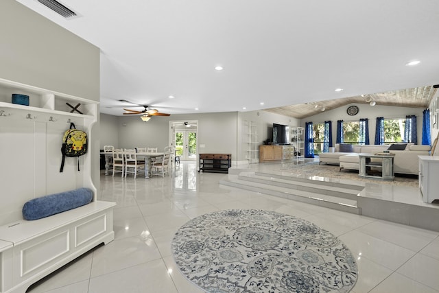 living room featuring lofted ceiling, light tile patterned flooring, visible vents, and plenty of natural light