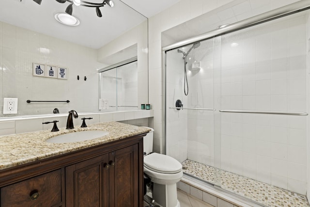 bathroom with a stall shower, toilet, and vanity