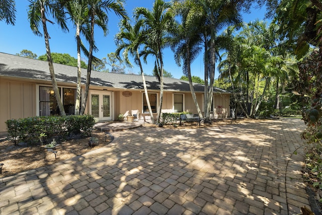 rear view of property with french doors and board and batten siding