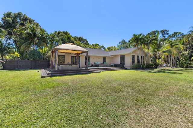 rear view of house featuring a gazebo, a yard, a deck, and fence