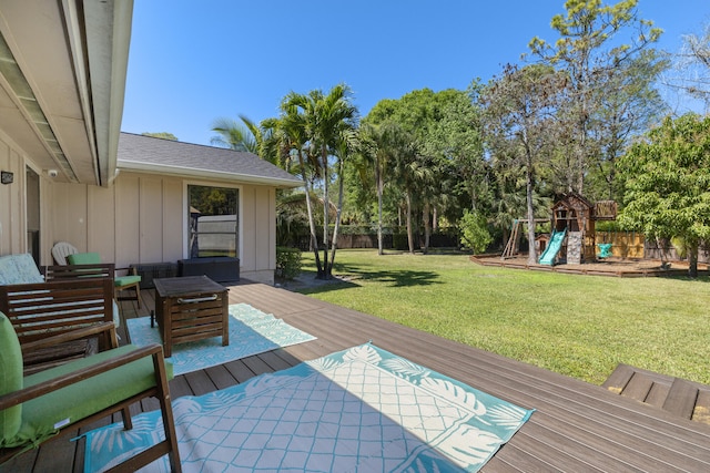 wooden terrace with a yard, a fenced backyard, and a playground