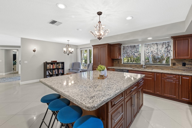 kitchen featuring a sink, tasteful backsplash, a chandelier, and light tile patterned floors