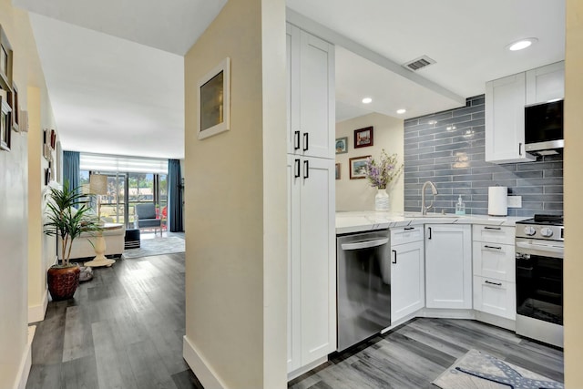 kitchen featuring light stone counters, stainless steel appliances, visible vents, white cabinetry, and tasteful backsplash