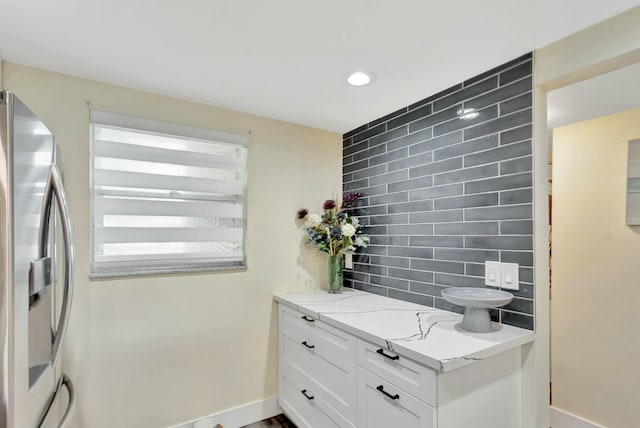 bathroom with recessed lighting, baseboards, backsplash, and vanity