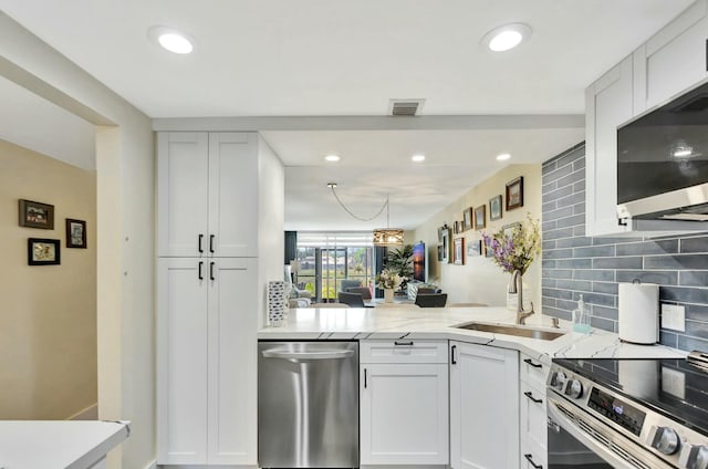 kitchen featuring visible vents, decorative backsplash, stainless steel appliances, a sink, and recessed lighting