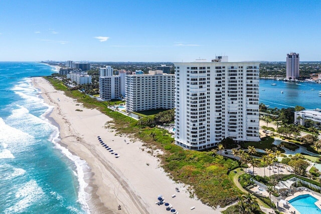 drone / aerial view featuring a view of city, a beach view, and a water view