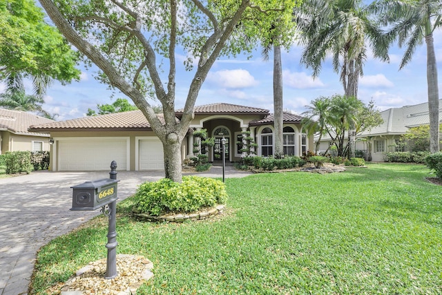 mediterranean / spanish-style home with a front yard, decorative driveway, an attached garage, and stucco siding