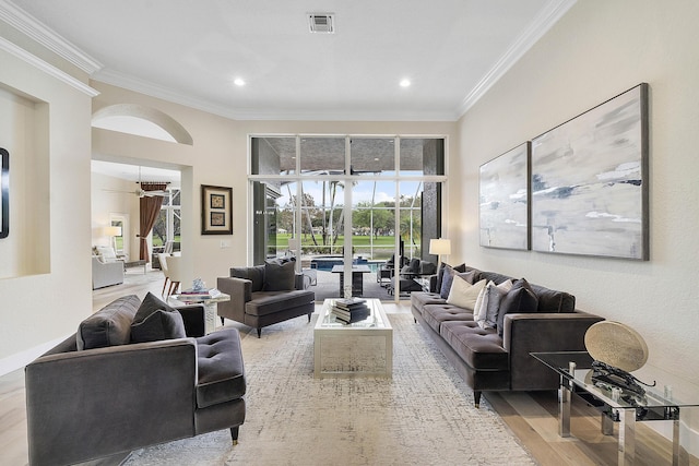 living area with ornamental molding, recessed lighting, visible vents, and light wood finished floors