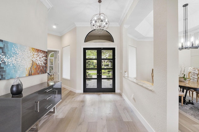 foyer with a chandelier, ornamental molding, and light wood-style flooring