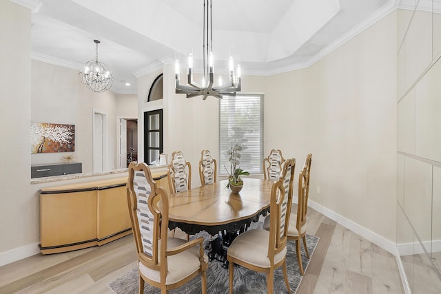 dining space featuring ornamental molding, light wood-type flooring, a notable chandelier, and baseboards