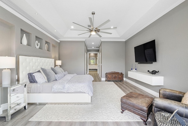 bedroom featuring crown molding, a tray ceiling, wood finished floors, and recessed lighting