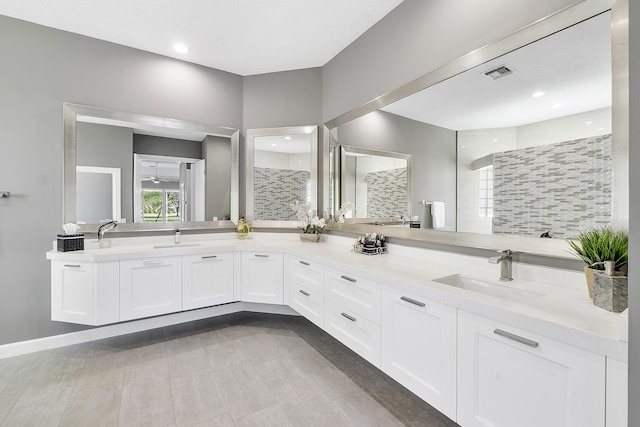 bathroom featuring double vanity, visible vents, a sink, and recessed lighting