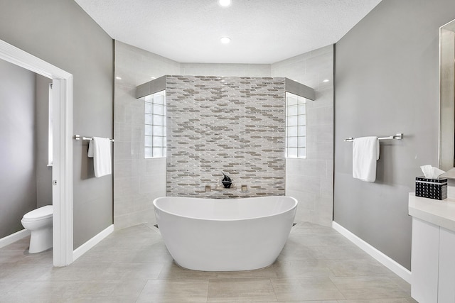 bathroom featuring a textured ceiling, walk in shower, a freestanding tub, and toilet