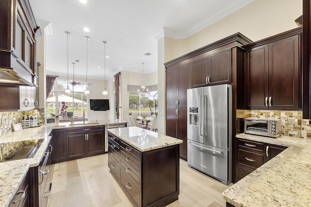 kitchen with black electric stovetop, high quality fridge, light stone counters, ornamental molding, and pendant lighting