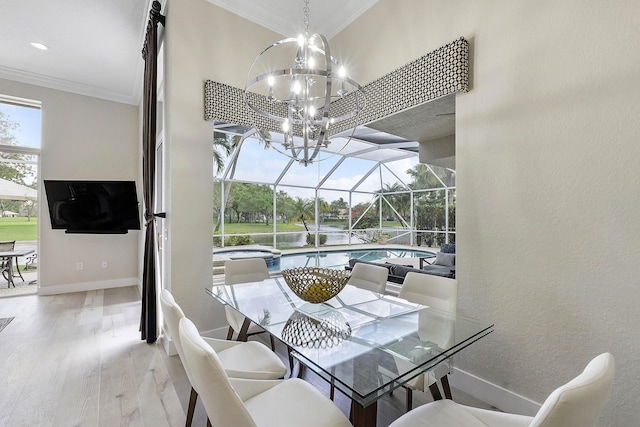 dining area featuring a sunroom, crown molding, baseboards, and wood finished floors