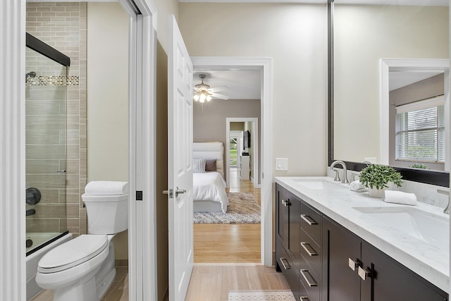 ensuite bathroom with toilet, double vanity, a sink, and ensuite bathroom