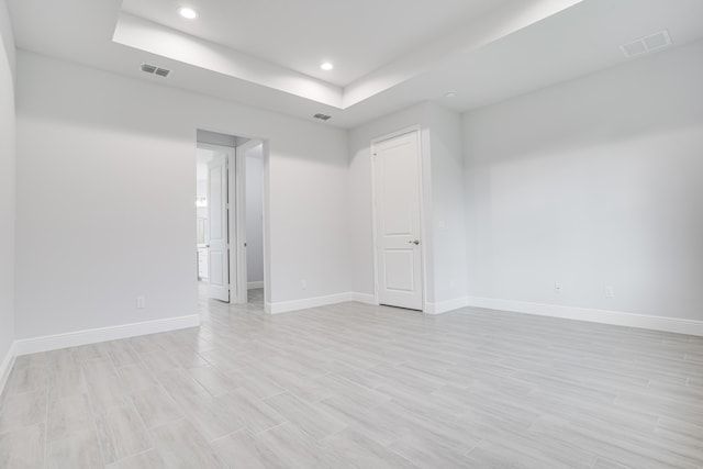 unfurnished room featuring recessed lighting, a raised ceiling, visible vents, and baseboards