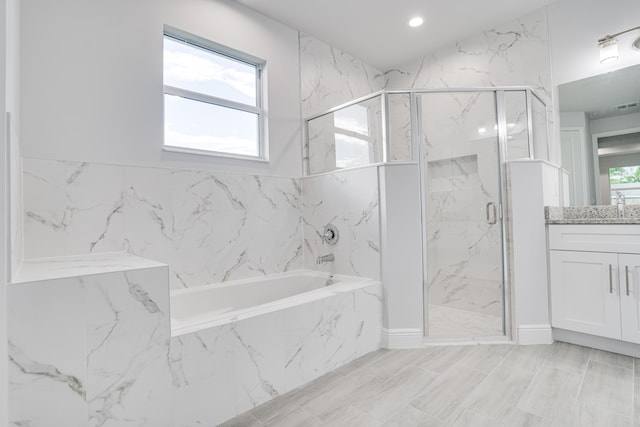 bathroom featuring a garden tub, a marble finish shower, vanity, and recessed lighting