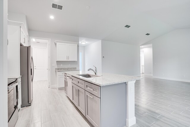 kitchen featuring a kitchen island with sink, visible vents, stainless steel appliances, and a sink