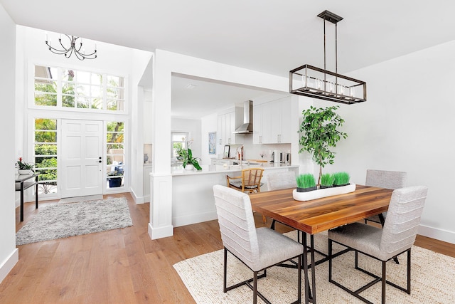 dining space featuring an inviting chandelier, baseboards, and light wood finished floors