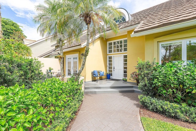 property entrance featuring stucco siding and french doors