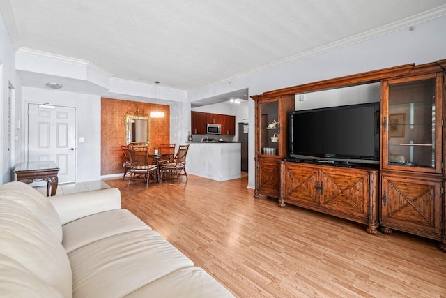 living area featuring crown molding, light wood-style flooring, and baseboards