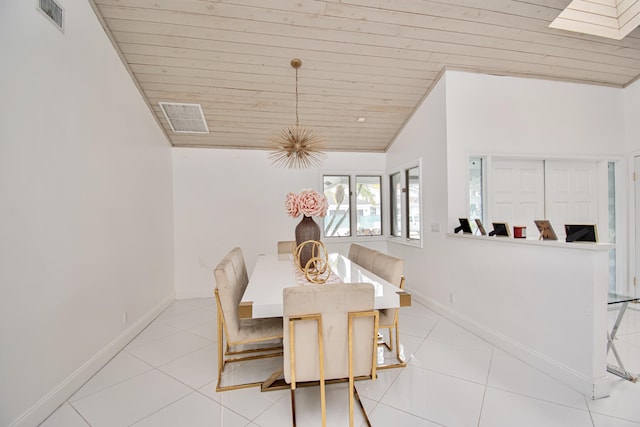 dining room with visible vents, lofted ceiling with skylight, light tile patterned floors, baseboards, and wood ceiling