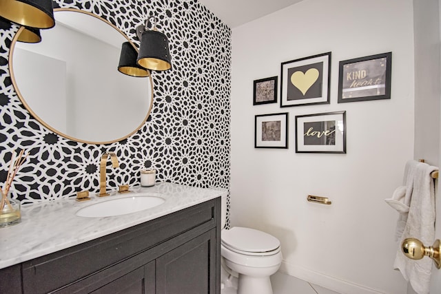 bathroom featuring vanity, tile patterned floors, toilet, and baseboards