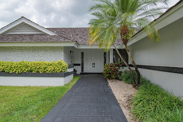 doorway to property featuring stucco siding and an attached garage