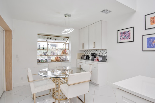 dining area featuring light tile patterned floors, baseboards, visible vents, and a chandelier