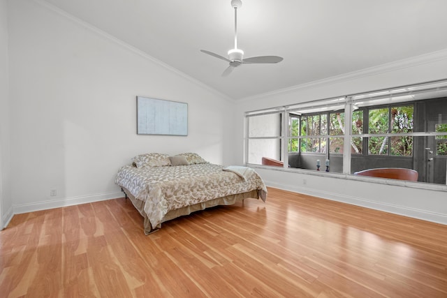 bedroom featuring ornamental molding, vaulted ceiling, light wood-style flooring, and baseboards