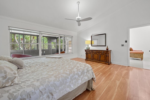 bedroom featuring vaulted ceiling, light wood finished floors, baseboards, and crown molding