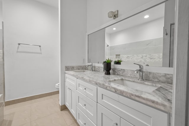 bathroom with walk in shower, a sink, toilet, and double vanity