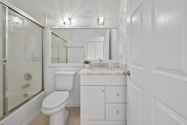 bathroom featuring toilet, vanity, and enclosed tub / shower combo