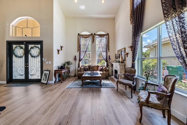 foyer entrance featuring french doors, a high ceiling, baseboards, and wood finished floors