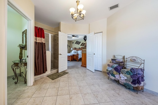 entryway featuring light tile patterned floors, ceiling fan with notable chandelier, and visible vents