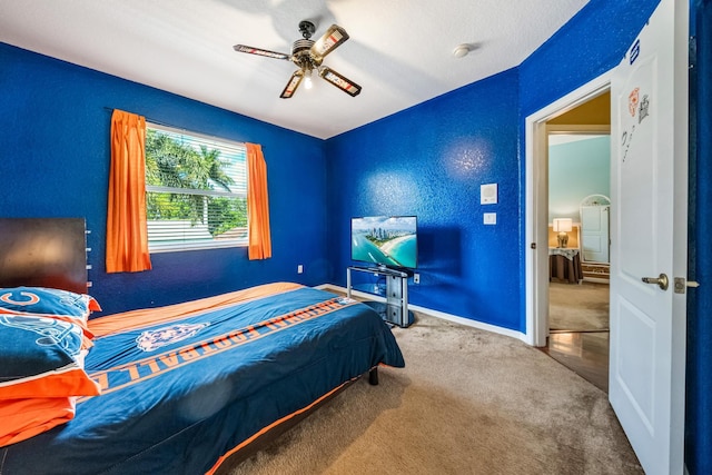 carpeted bedroom with a textured wall, baseboards, and ceiling fan