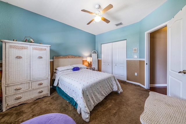 carpeted bedroom featuring visible vents, baseboards, a textured wall, a closet, and a ceiling fan