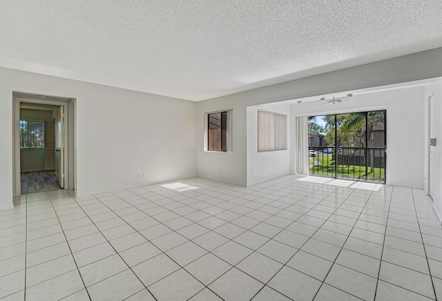 unfurnished room with a textured ceiling and light tile patterned floors