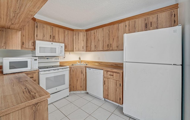 kitchen featuring white appliances, light tile patterned flooring, a sink, and a textured ceiling